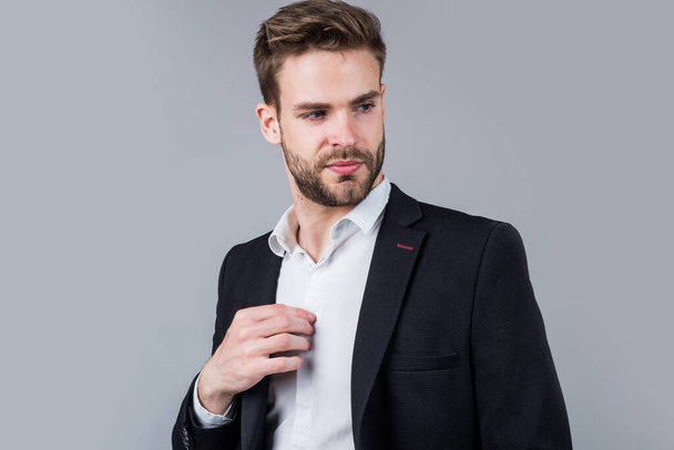 Feeling flirty. Young manager in his office. portrait of a businessman on grey background. confident businessman portrait. Portrait of a handsome CEO. Businessman in suit. Young handsome man - Foto, Imagen