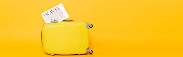 travel newspaper on colorful suitcase on yellow background, panoramic shot - Φωτογραφία, εικόνα