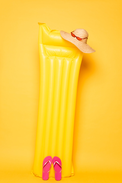 pool float with beach accessories on yellow background - Φωτογραφία, εικόνα