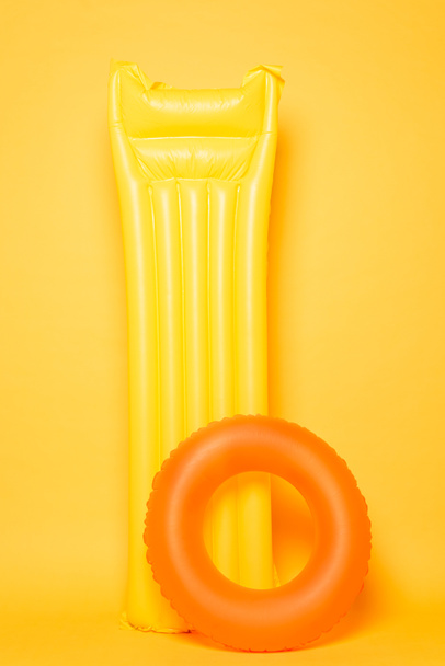 pool float and swim ring on yellow background - Фото, изображение