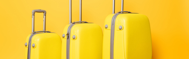 stack of travel bags on yellow background, panoramic shot - Photo, Image