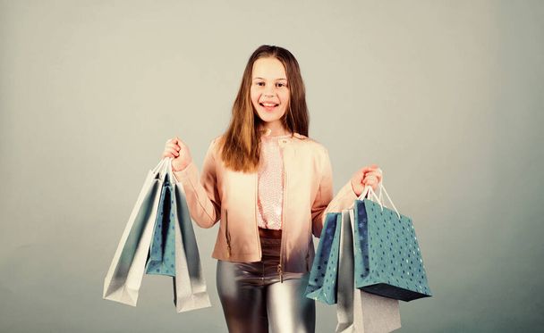 Happy child in shop with bags. Shopping day happiness. Buy clothes. Birthday girl shopping. Fashion boutique. Fashion trend. Fashion shop. Little girl with bunch packages. Fashion girl customer - Фото, зображення