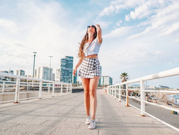 woman in sexy stylish clothes posing in the modern city with skyscrapers on background - Photo, Image