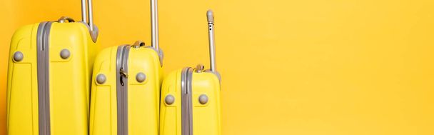 stack of travel bags isolated on yellow background, panoramic shot - Valokuva, kuva