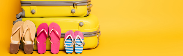 travel bags with family flip flops isolated on yellow, panoramic shot - Photo, Image