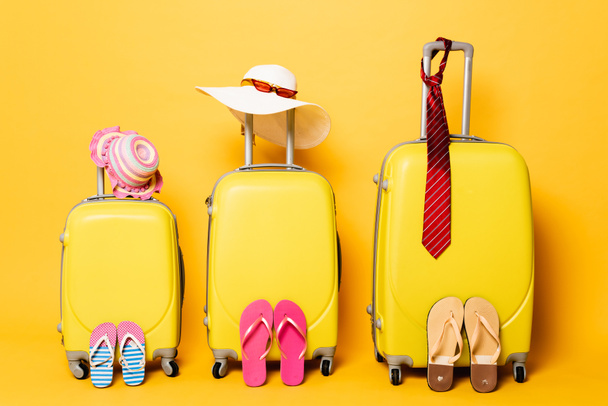 familie reistassen met strand zomer accessoires op geel - Foto, afbeelding
