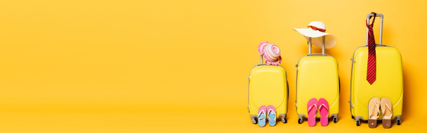 family travel bags with beach summer accessories isolated on yellow, panoramic shot - Foto, Imagem