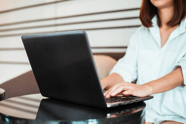 jovem mulher trabalhando no computador portátil enquanto sentado na sala de estar. trabalho a partir de casa conceito - Foto, Imagem