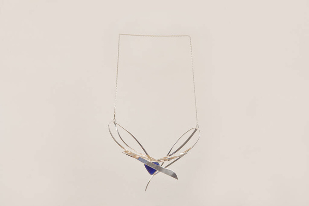 női ezüst nyaklánc lapis lazuli. Luxus nyaklánc gyönyörű ezüst akcentussal szürke alapon. - Fotó, kép