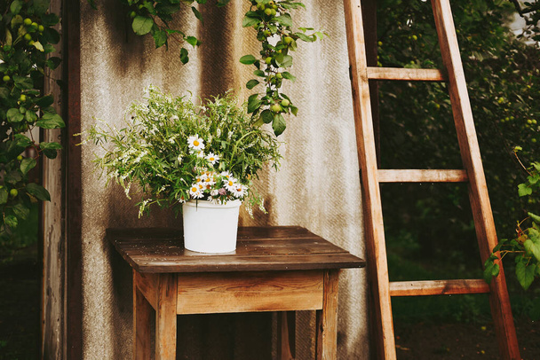 Λουλούδια ένα ξύλινο τραπέζι Μπουκέτο με αγριολούλουδα και χαμομήλια Αυθεντικό στυλ - Φωτογραφία, εικόνα