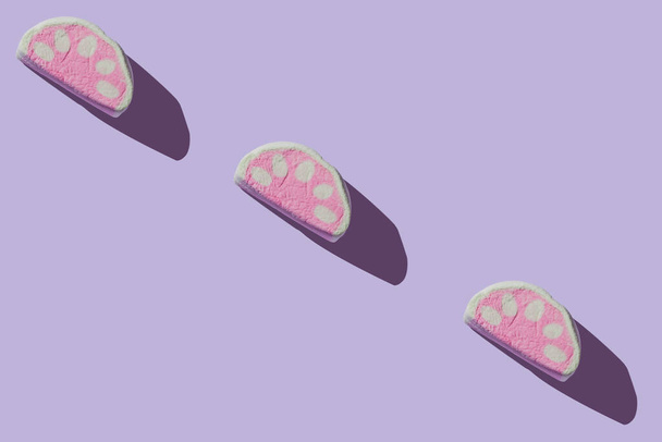Vários deliciosos marshmallows com sombras duras em um fundo lilás pastel com espaço de cópia
 - Foto, Imagem