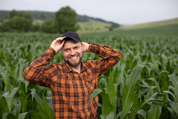 Portrait of a happy smiling farmer on a green corn field. Agriculture - Fotoğraf, Görsel