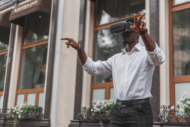 Empresario africano usa gafas de realidad virtual en la calle. Auriculares VR
. - Foto, imagen