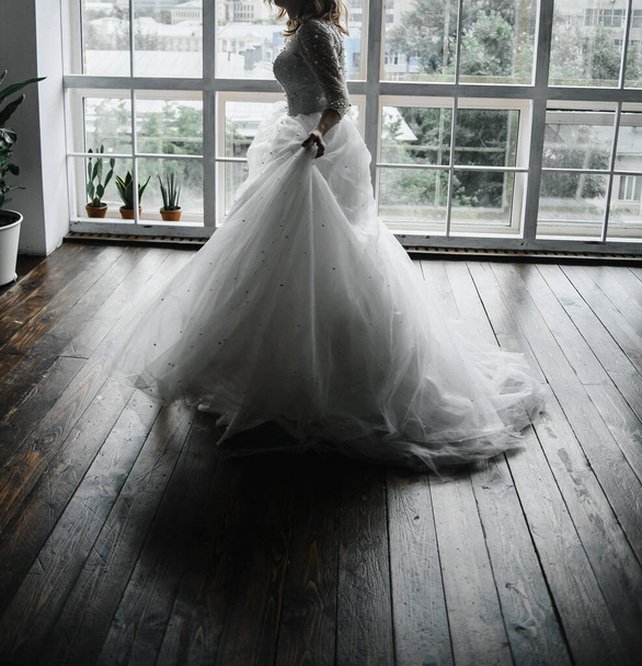 νεαρή λεπτή νύφη σε ένα μακρύ λευκό κομψό νυφικό. γαμήλια τελετή - Φωτογραφία, εικόνα