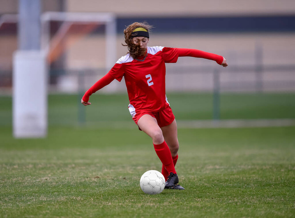 Young attractive athletic girl playing soccer in a game - Photo, Image