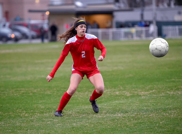 Genç çekici atletik kız bir oyunda futbol oynuyor. - Fotoğraf, Görsel
