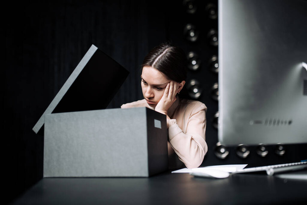 Business girl in beige blouse opens black box and looks bored without interest in the office - Foto, immagini