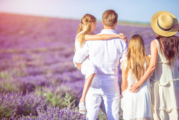 Rodina v levandulových květinách pole při západu slunce v bílých šatech a klobouku - Fotografie, Obrázek