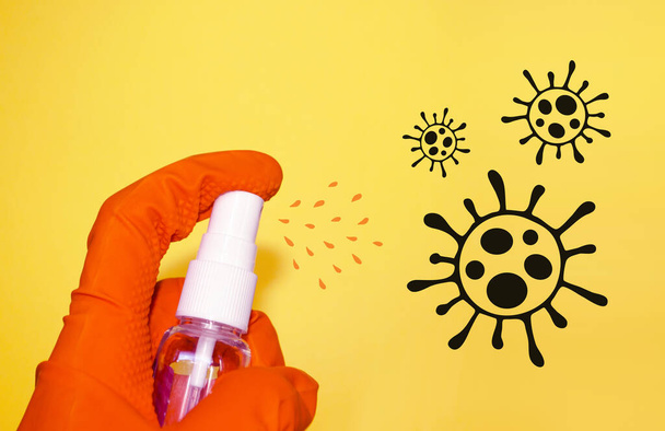 Main dans le gant de protection utilise un désinfectant pulvérisation pour tuer le coronavirus. Auto-protection en quarantaine. Assainissez vos mains et prenez soin de votre santé.  - Photo, image