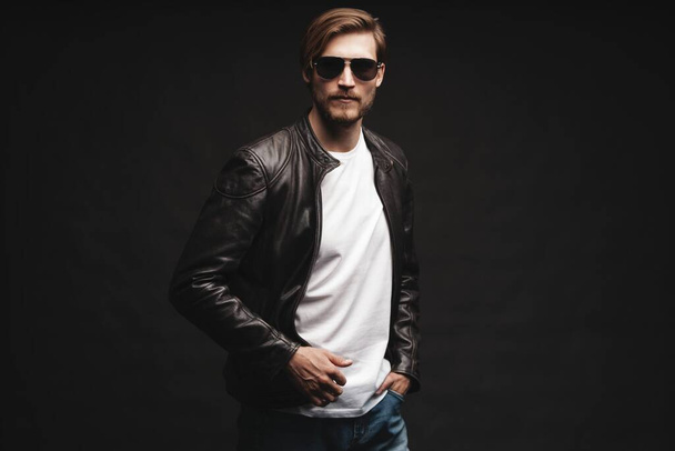 Fashion man, Handsome beauty male model portrait wear sunglasses and leather jacket, young guy over black background. - Φωτογραφία, εικόνα