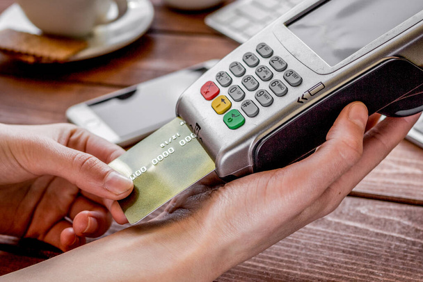 Payment by card in cafe with terminal and keyboard on wooden background - Foto, Imagem