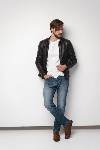 Fashion man, Handsome serious beauty male model portrait wear leather jacket, young guy over white background. - Fotografie, Obrázek