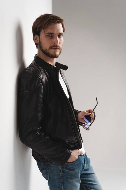Fashion man, Handsome serious beauty male model portrait wear leather jacket, young guy over white background. - Φωτογραφία, εικόνα