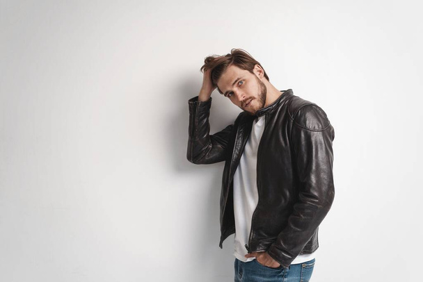 Fashion man, Handsome serious beauty male model portrait wear leather jacket, young guy over white background. - 写真・画像