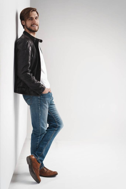 Fashion man, Handsome serious beauty male model portrait wear leather jacket, young guy over white background. - 写真・画像