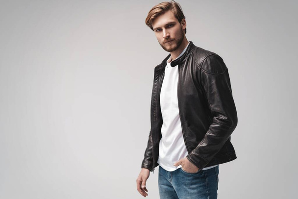 Fashion man, Handsome serious beauty male model portrait wear leather jacket, young guy over white background. - Photo, image