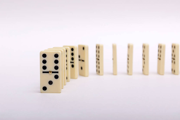 Composição de efeito de dominó de um múltiplo ossos de dominó colocados em uma fileira em fundo branco. Imagem de alta resultado
. - Foto, Imagem