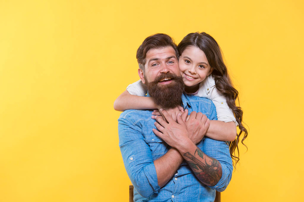 Love is main ingredient. Happy daughter hug father with love. Bearded man and little child. Happy family yellow background. Relationship and relations. Rooted and grounded in love. Trust and care - Foto, Bild