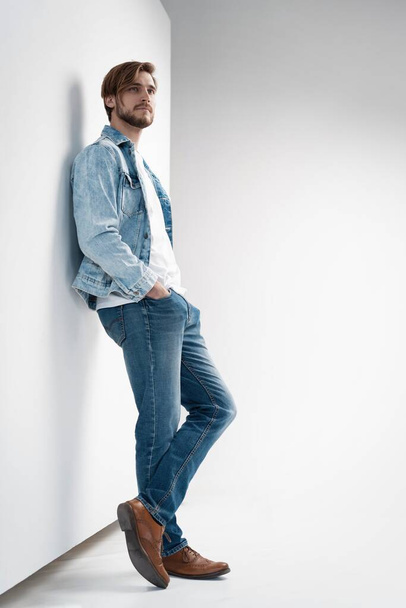 Fashion portrait of young man wearing jeans jacket. - Фото, зображення
