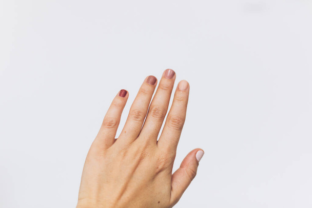Pregos femininos com diferentes cores pastel no fundo branco. Casa manicure moderna. Mão feminina levantada. Direitos da mulher
 - Foto, Imagem