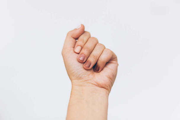 Жіночий кулак протестує на білому тлі. Жіноча рука піднята різними кольорами нігтів, шкірою та різноманітністю раси. Концепція прав жінок. Зупинити расизм
 - Фото, зображення