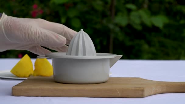 Squeezing lemon on outdoor table - Imágenes, Vídeo