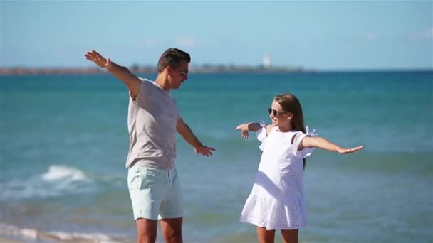 Küçük kız ve mutlu baba kumsal tatili boyunca eğleniyorlar. - Video, Çekim