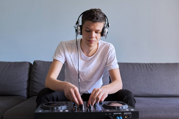 Creative teen boy in headphones with mixer equipment entertainment dj station - Foto, Imagem