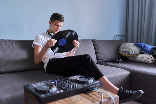 Creative teen boy with vinyl records, young man in headphones interested in music - Fotó, kép