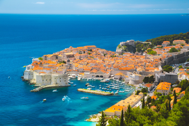 Panoramic aerial view of the historic town of Dubrovnik, one of the most famous tourist destinations in the Mediterranean Sea, from Srt mountain on a beautiful sunny day in summer, Dalmatia, Croatia - Photo, Image