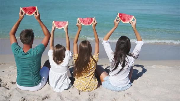onnellinen perhe syö vesimelonia rannalla. - Materiaali, video