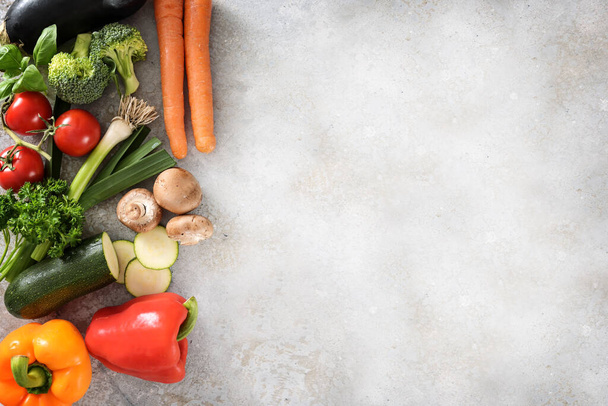 Colorful organic vegetables on the side of a light gray surface with large copy space, healthy kitchen background, high angle view from above - Foto, Bild