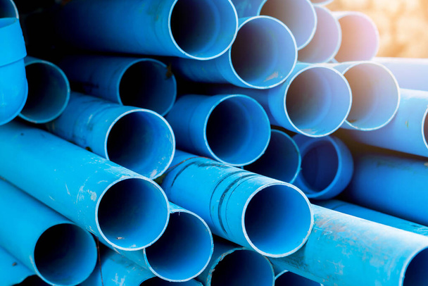 Fondo de tubo de plástico selectivo a azul. Tubos de PVC apilados en almacén de obra. Tubos de agua de PVC utilizados para la construcción
. - Foto, imagen