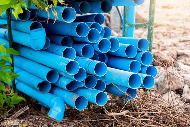 Избирательный к синему фону пластиковых труб. ПВХ трубы укладываются на склад строительной площадки. ПВХ водопроводы, используемые для строительства. - Фото, изображение