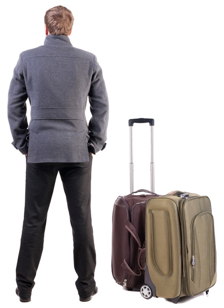 Back view of young man traveling with suitcase. - Foto, imagen