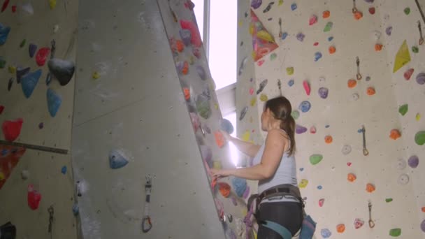 LENS FLARE: Bright sunbeams shine on a girl climbing a route in an indoor center - Footage, Video