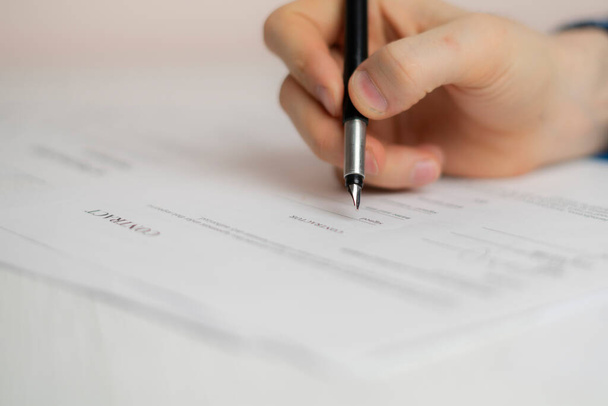 mano de la persona sosteniendo un bolígrafo y firmar el contrato de documento en el cargo, concepto de éxito del acuerdo - Foto, imagen