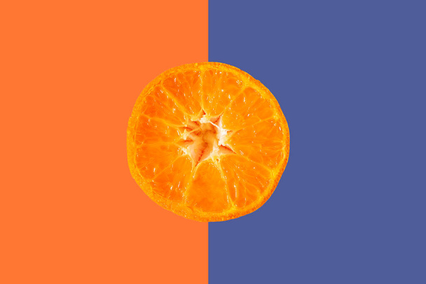 カラフルなパステルカラーの背景にオレンジの柑橘類のスライス、シンプルなミニマリストのコンセプト - 写真・画像
