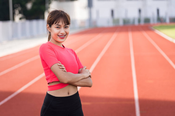 Portrait of a fit and frim young woman wears sport clothes ready to workout in the city stadium in the morning. Healthy and recreation stock photo. - Photo, Image