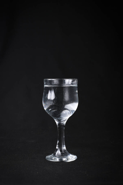 Wasser spritzt aus Glas auf schwarzem Hintergrund. Mit grünen Trauben. - Foto, Bild